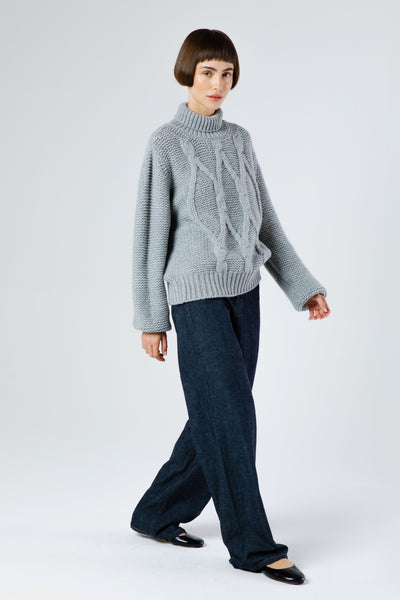 Front view of Dolci Cable Cashmere Pullover — soft blue-grey Italian cashmere with oversized cable-knit design, ribbed turtleneck, and non-pilling texture.